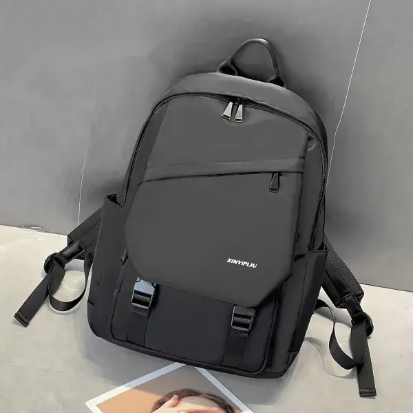 Dyed Black backpack, front view, showing the front flap, two buckle straps, and pockets