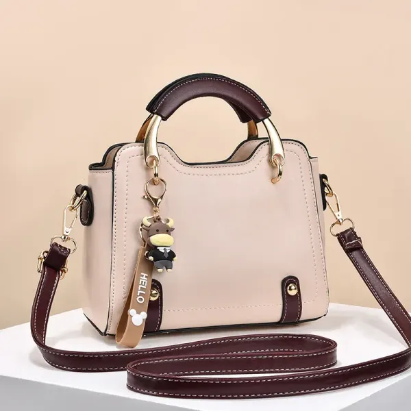 Front view of a light handbag with arched handles and contrasting trim