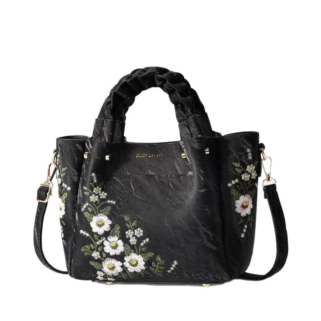Jet Black Floral bag with braided handles and a long strap against a white background