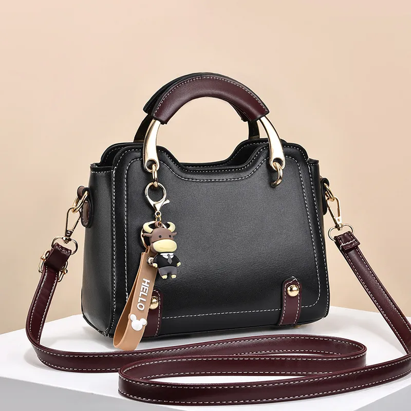 Front view of a dark handbag with arched handles and gold-tone supports