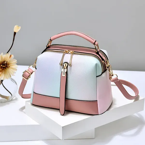 Pastel gradient handbag with pink trim, a top handle, and a long strap