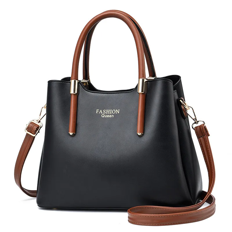 Jet Black tapered handbag with brown top handles, a long brown strap, and gold-tone collars