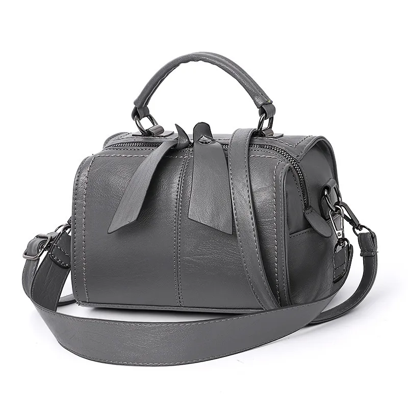 Charcoal rounded handbag with a top handle, long strap and two dangling zipper pulls