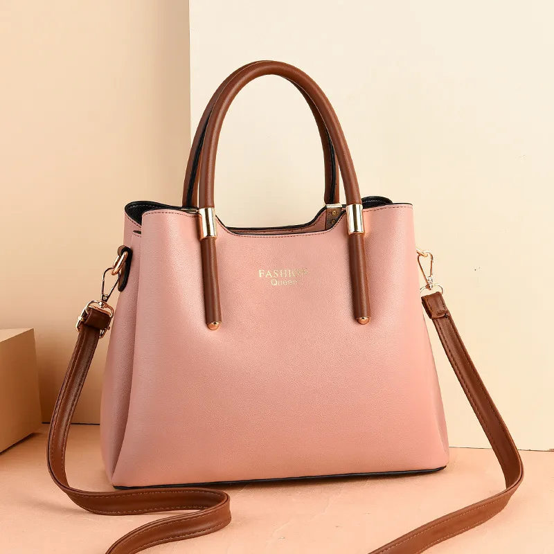 Tapered handbag with brown top handles, a long brown strap, and gold-tone collars