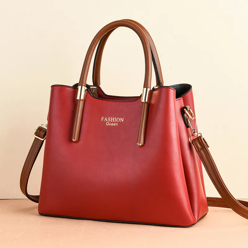 Tapered handbag with brown top handles, a long brown strap, and gold-tone collars